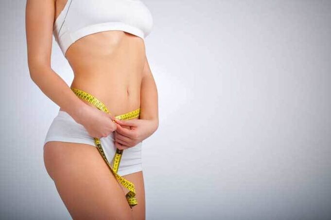 Slender girl measures the waist volume