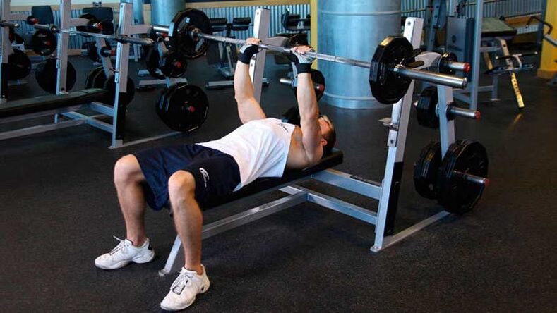 In order to dry the shoulders and chest, a barbell bench press is performed on a horizontal bench. 